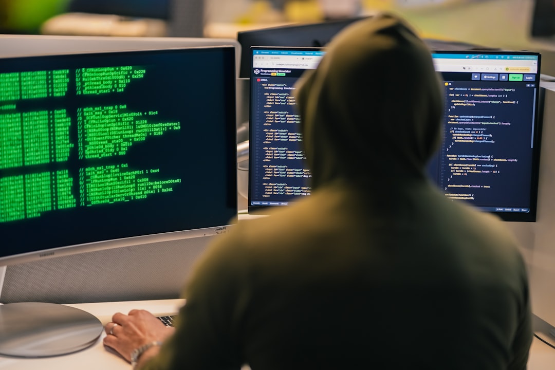 hacker-in-hoodie-working-on-multiple-computer-screens-hlamfdxglls